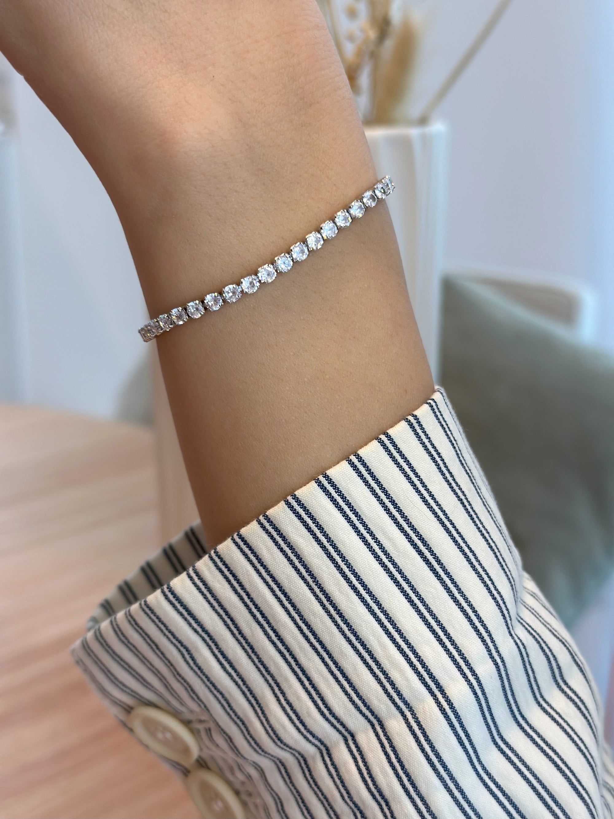 Eleganter Tennisarmband mit Zirkonia und silberfarbenen Details-auf dem Bild trägt ein Model diesen Armschmuck