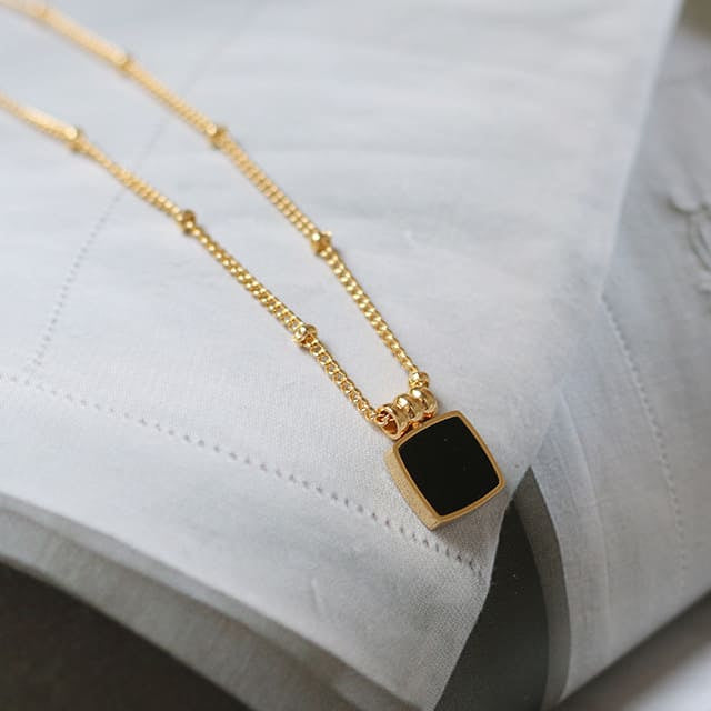 Goldene Halskette mit schwarzem Anhänger mit Deko