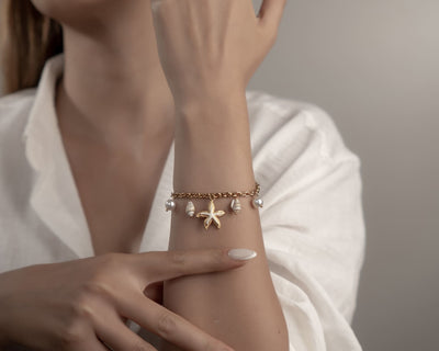 Armband mit goldenen Seesternen und weisser Emaille Füllung